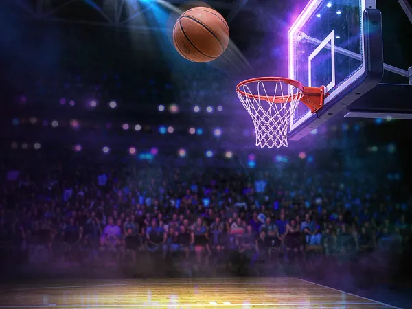 sportsbet.io + Basketball approaching a hoop in a brightly lit arena